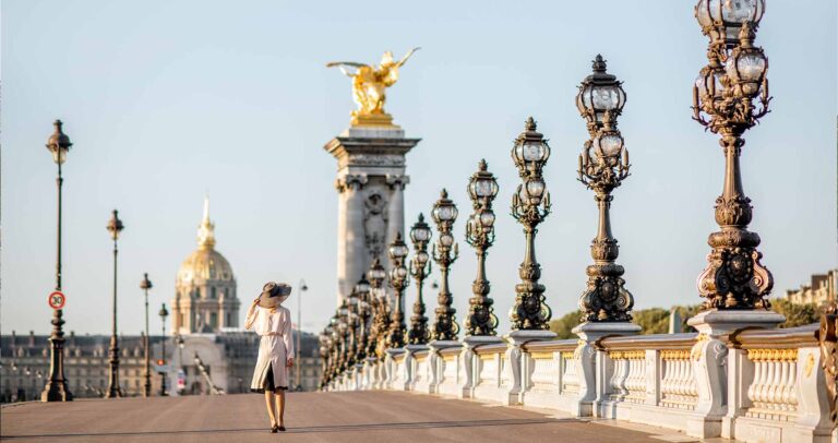 woman walking across the alexander bridge in paris
